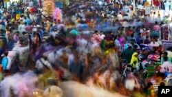 People move through a market in Mumbai, India, Nov. 12, 2022.