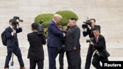 Presiden AS Donald Trump (kiri) bertemu dengan pemimpin Korea Utara Kim Jong Un di zona demiliterisasi Panmunjom, Korea Selatan, pada 30 Juni 2019. (Foto: Reuters/Kevin Lamarque)