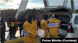 Rekonstruksi juga memperlihatkan tubuh korban dalam karung diperberat dengan bongkahan batu agar tenggelam. (Foto: Courtesy/Polres Mimika)