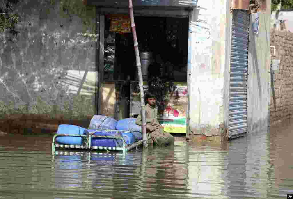 A man sits in front of a flood-damaged shop in Jaffarabad, Pakistan, Sept. 5, 2022. 
