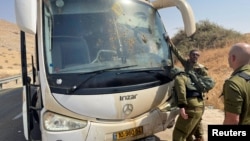 سربازان اسرائیلی در کنار اتوبوسی که توسط دو ضارب فلسطینی هدف تیراندازی قرار گرفت (آرشیو)