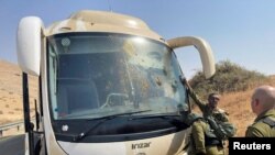 سربازان اسرائیلی در کنار اتوبوسی که از سوی دو ضارب فلسطینی هدف تیراندازی قرار گرفت. دره اردن در کرانه باختری. ۴ سپتامبر ٢٠٢٢