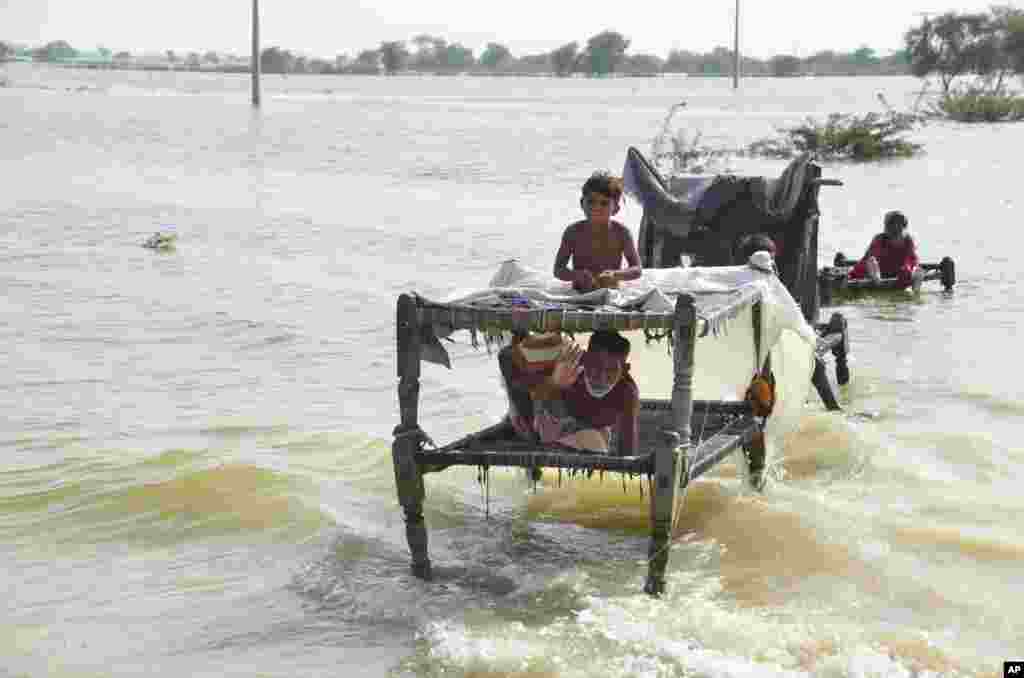 People are seen surrounded by floodwaters, in Sohbat Pur city, a district of Pakistan&#39;s southwestern Baluchistan province, Sept. 3, 2022.