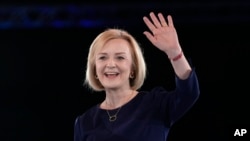 FILE - Liz Truss waves on stage after a Conservative leadership election hustings at Wembley Arena in London, Aug. 31, 2022. 