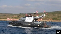 Lebanese protesters ride in a yacht with an Arabic banner that reads "No compromises No waivers, No negligence, Our maritime resources belong to us," during a demonstration demanding Lebanon's right to its maritime oil and gas fields, Naqoura, Lebanon, Sept. 4, 2022.