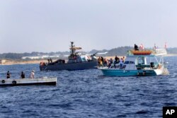 Lebanese protesters sail near an Israeli Navy vessel during a demonstration demanding Lebanon's right to its maritime oil and gas fields, in the southern marine border town of Naqoura, Lebanon, Sept. 4, 2022.