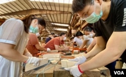 Students of the carpentry class at the Chi Kee Sawmill & Timber learns to polish wood. (Iris Tong, VOA Cantonese Service)