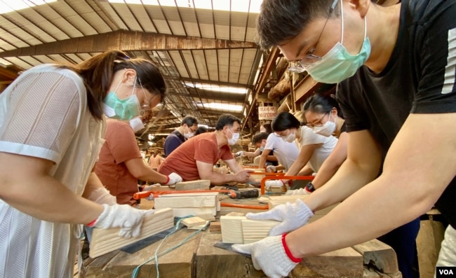 Students of the carpentry class at the Chi Kee Sawmill & Timber learns to polish wood. (Iris Tong, VOA Cantonese Service)