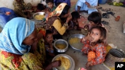 Victims of the unprecedented flooding from monsoon rains receive relief food organized by the Alkhidmat Foundation, in Jaffarabad, a district of Pakistan's southwestern Baluchistan province, Sept. 5, 2022. 