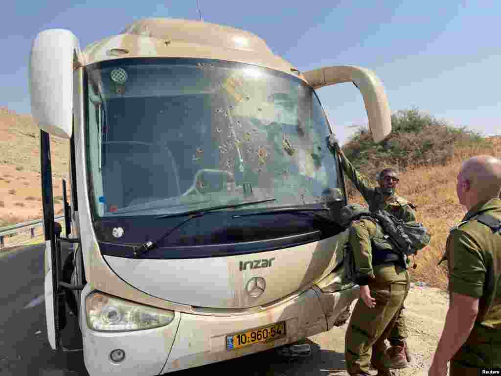 Israeli soldiers check damage in a bus, at the scene of a shooting attack in the Jordan Valley, in the Israeli-occupied West Bank.