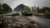 FILE - A Ukrainian tank passes a former Russian checkpoint in the recently retaken area of Izium, Ukraine, Sept. 16, 2022. 