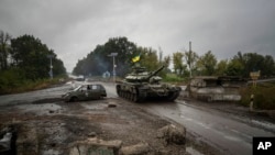 A Ukrainian tank passes a former Russian checkpoint in the recently retaken area of Izium, Ukraine, Sept. 16, 2022. 
