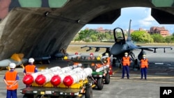 Archivo-Personal militar junto al Harpoon A-84 de Estados Unidos, misiles antibuques y misiles aire-aire AIM-120 y AIM-9 preparados para ejercicios de carga de armas frente a un avión de combate F-16V de Estados Unidos en la base aérea de Hualien, Taiwán, el 17 de agosto de 2022.