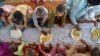Children eat food provided by a charity group, in Jaffarabad, a flood-hit district of Baluchistan province, Pakistan, Sept. 15, 2022.