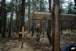 Oleg Kotenko, komesar za pitanja nestalih osoba, snima kamerom na telefonu neidentifikovane grobove civila i ukrajinskih vojnika u Izijumu, 15. septembra 2022.