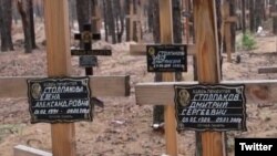 FILE- Grave markers listing the names of victims are seen at a recently discovered mass burial site in Izium, Kharkiv region, Ukraine.