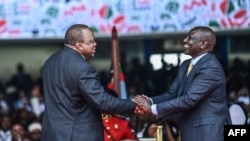 FILE - Outgoing Kenyan President Uhuru Kenyatta shakes hands with President William Ruto at the Moi International Sports Center, in Nairobi, Kenya, Sept. 13, 2022, during Ruto's inauguration.