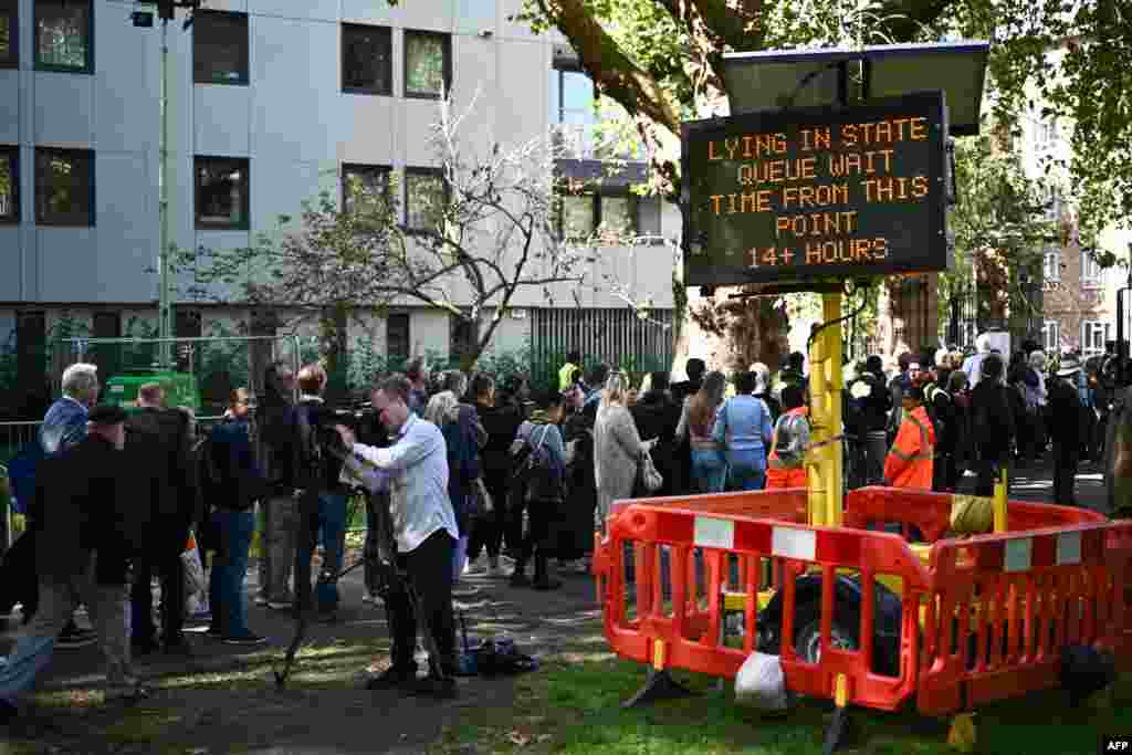 A digital sign board shows the wait time at Southwark Park, as people stand in line to pay their respects to the late Queen Elizabeth II, in London.
