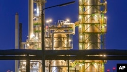 FILE - The facilities of the oil refinery on the industrial site of PCK-Raffinerie GmbH, jointly owned by Rosneft, are illuminated in the evening in Schwedt, Germany, on May 4, 2022.
