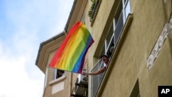 FILE - A woman waves a rainbow flag as she shouts slogans during the LGBTQ Pride March in Istanbul, Turkey, June 26, 2022. 