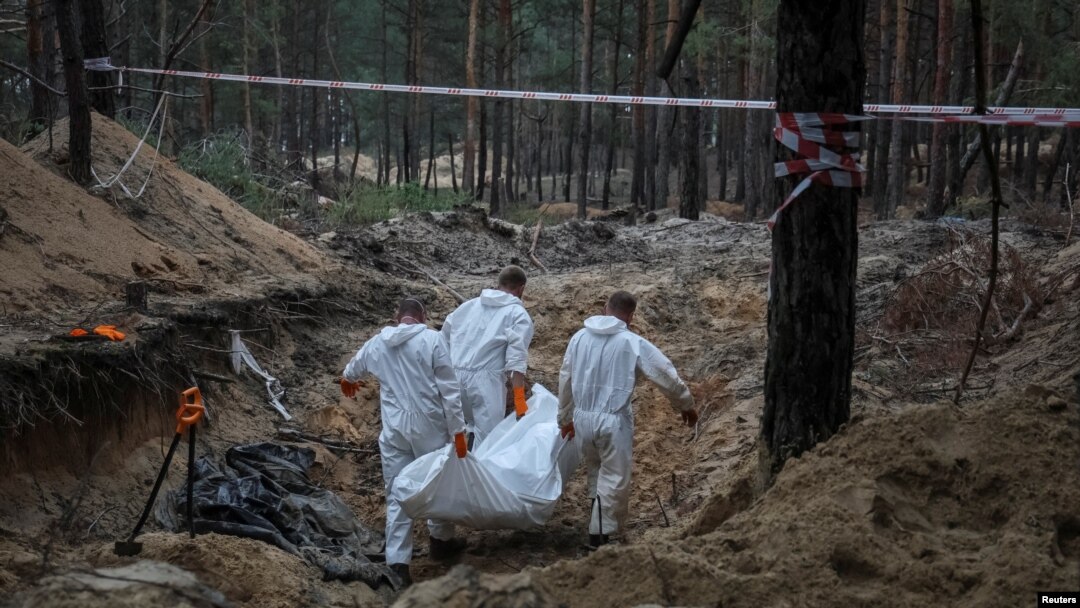 Eksperti iskopavaju tela iz masovne grobnice u gradu Izjum, na severoistoku Ukrajine (Foto: REUTERS/Gleb Garanich)