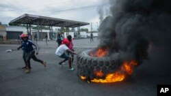 Manifestan boule yon kawotchou pou kom barikad pandan yon manifestasyon kont ogmantasyon pri gaz la e pou mande Premye Minis Ariel Henry bay demisyon li nan Potoprens, Vandredi 16 Sept. 2022. 