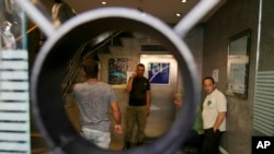 Security men gather at the entrance of BLOM bank branch where a man who is identified as Abed Soubra is allegedly holding hostages in an effort to get to funds in his account in Beirut, Lebanon, Sept. 16, 2022.