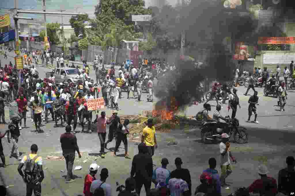 La gente camina quemando llantas colocadas en una manifestación de protesta para exigir que el primer ministro haitiano, Ariel Henry, renuncie y en un llamado a una mejor calidad de vida, en Puerto Príncipe, Haití, el miércoles 7 de septiembre de 2022.