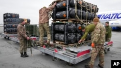 FILE - Ukrainian servicemen unpack Javelin anti-tank missiles, delivered as part of a U.S. security assistance package, at the Boryspil airport, outside Kyiv, Ukraine, Feb. 11, 2022.