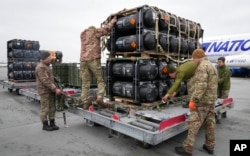 FILE - Ukrainian servicemen unpack Javelin anti-tank missiles, delivered as part of a U.S. security assistance package, at the Boryspil airport, outside Kyiv, Ukraine, Feb. 11, 2022.