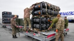 Prajurit Ukraina membongkar rudal anti-tank Javelin, yang dikirimkan sebagai bagian dari paket bantuan keamanan AS ke Ukraina, di bandara Boryspil, di luar Kyiv, Ukraina, 11 Februari 2022. (Foto: Efrem Lukatsky/AP Photo)