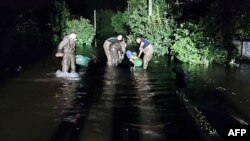 FILE: This picture released by Ukrainian Emergency Service, Sept. 15, 2022, shows rescuers and the flooding caused by Russian missile strikes to a dam near the city of Kryvyi Rih, Sept. 14, 2022.