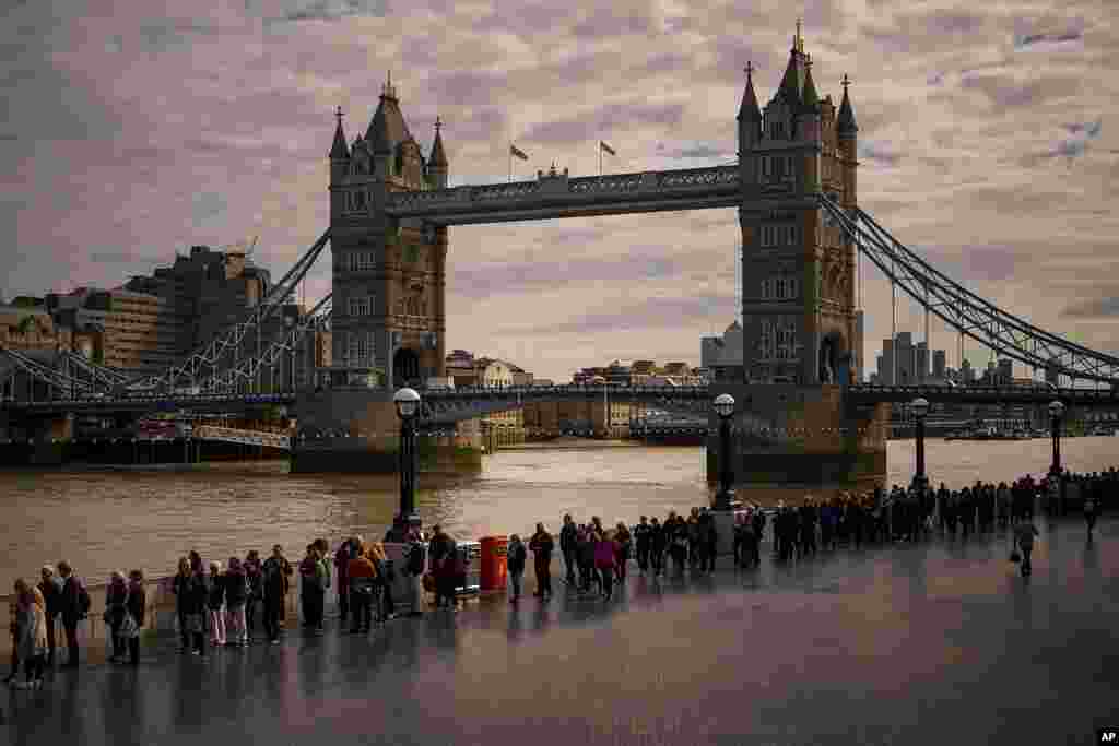 Orang-orang mengantre di dekat Jembatan London Jumat (16/9) untuk memberi penghormatan kepada mendiang Ratu Elizabeth II, yang disemayamkan di Westminster Hall di London. (Foto: AP)