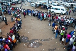 People queue for public transport in Harare, Zimbabwe, March, 23, 2020. Zimbabwe has closed its borders to non-essential human traffic following its first recorded coronavirus-related death.
