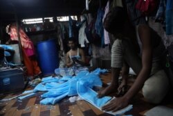 Indian workers make face masks which are in demand due to the new virus outbreak at a private manufacturing unit in Mumbai, India, March 17, 2020.