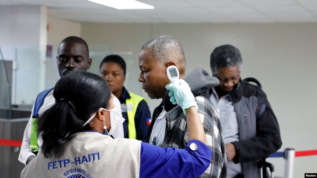 Seorang pelancong tiba di Bandara Internasional Toussaint Louverture, Port-au-Prince, diperiksa suhunya sebagai bagian dari langkah-langkah untuk mencegah masuknya virus corona di Haiti, 4 Februari 2020. (Foto: Reuters/Valerie Baeriswyl)