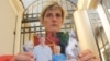 Brenda Caplen holds a photo of her son, Stuart (far left in photograph), who was killed in a collision in which alcohol was a deemed major causal factor. (D. Taylor/VOA)