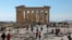 FILE - People visit the ancient Parthenon Temple atop the Acropolis hill archaeological site in Athens, Greece, Feb. 26, 2022.