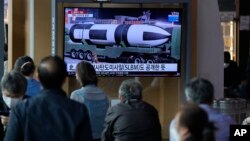 FILE: People watch a TV screen showing a news program reporting about North Korea's military parade with an image at a train station in Seoul, South Korea, April 26, 2022.
