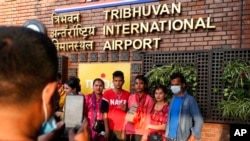 A Nepalese migrant worker takes photos with his family before taking a flight to Qatar at Tribhuvan International airport in Kathmandu, Nepal, April 15, 2022.
