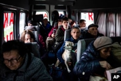 FILE - People sit in a bus during evacuation from Lyman, Donetsk region, eastern Ukraine, April 30, 2022.