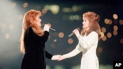 FILE - Wynonna Judd, left, and her mother, Naomi Judd, of The Judds, perform during the halftime show at Super Bowl XXVIII in Atlanta on Jan. 30, 1994.