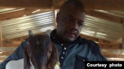 Journalist Hopewell Chin'ono holding one of the Boer goats at his village