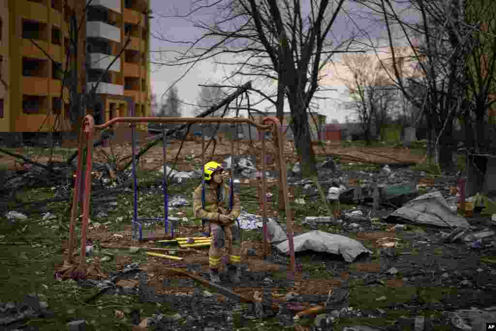 Un bombero se sienta en un columpio junto a un edificio destruido por una bomba rusa en Cherníhiv, Ucrania, el viernes 22 de abril de 2022. (AP Foto/Emilio Morenatti)