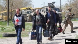 우크라이나 남동부 항구도시 마리우폴 시내 아조우스탈 제철소를 떠난 민간인들이 1일 최종 목적지인 자포리자에 도착하기 전, 국제적십자위원회(ICRC) 요원과 함께 도네츠크 지역에 있는 러시아 통제 임시 시설로 가고 있다. 