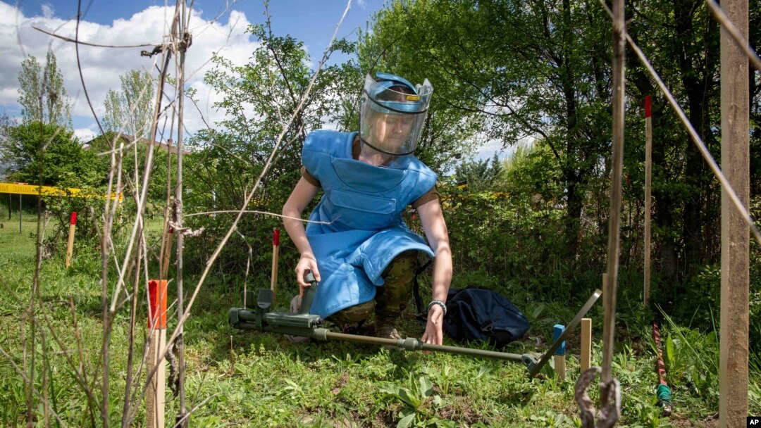 Anastasiia Minchukova lays a mine detector during a training session for a group of Ukrainian female emergency services personnel for specialist training in explosive ordnance disposal and survey training in the western Kosovo city of Peja, April 25, 2022.