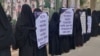 Members of Mahila Anjuman form a human chain in front of Dhaka press club with placards and banners demanding the removal of photos from NID. (Faisal Mahmud/VOA)