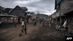 FILE - People walk down the main street of Muheto, a village on the outskirts of Masisi Centre, North Kivu province, eastern Democratic Republic of Congo, March 28, 2022.