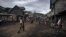 FILE - People walk down the main street of Muheto, a village on the outskirts of Masisi Centre, North Kivu province, eastern Democratic Republic of Congo, March 28, 2022.