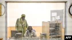 FILE - A journalist talks with his studio technician during a radio broadcast at ORTM's (Office of Radio and Television in Mali) Timbuktu office, in Timbuktu, Mali, Dec. 7, 2021.